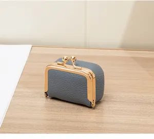 Détail d'une mini pochette à bijoux en cuir gris avec fermoir doré à clip rétro