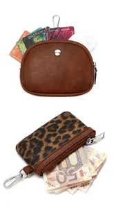 Close-up of leopard print and brown leather mini wallets with metal carabiner clips