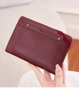 Detail of burgundy leather passport holder with elastic band and embossed passport logo
