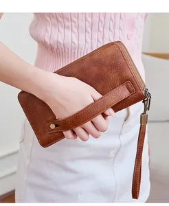 Dettaglio del portafoglio in pelle marrone vintage con doppia cerniera e cinturino