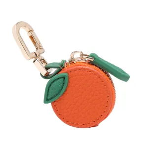 Detail of a mini orange coin purse keychain with realistic leather texture and gold clasp