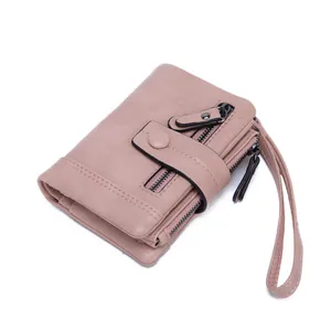 Women's pink RFID trifold wallet with double zippers, snap closure and wristlet strap