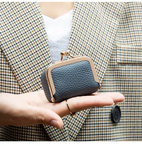 Détail du cuir gris grainé et du fermoir doré à clic pour ce mini porte-monnaie rétro