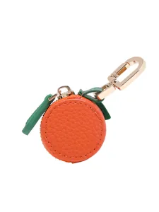 Detail of orange fruit coin purse with lychee texture leather and gold metal hook