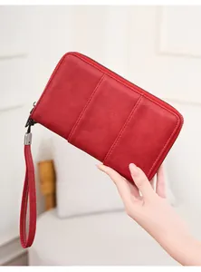 Detail of red RFID passport wallet with pebbled texture and matching wrist strap