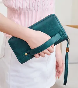 Dettaglio del portafoglio RFID in pelle verde acqua scuro con cinturino e zip vintage