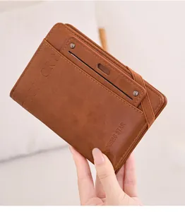 Detailed macro view of the brown leather passport wallet featuring an elastic strap