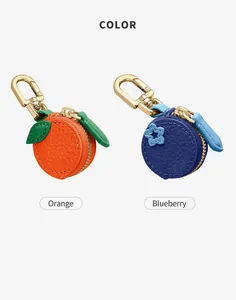 Detail of mini fruit coin purses in orange and blueberry leather with gold metal clips