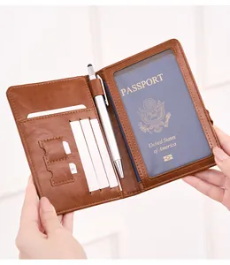 Detail view of brown leather passport wallet with card slots, SIM holder, and a pen loop