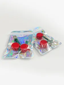 Detail of red cherry coin purse with lychee texture and gold zipper in holographic bag