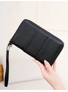 Close-up of black RFID passport wallet featuring fine leather texture and wrist strap