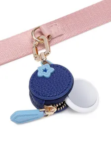 Macro detail of dark blue pebbled leather mini coin purse with golden star and pink strap