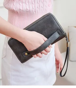 Dettaglio del portafoglio RFID grigio vintage con doppia zip e borchie in ottone antico