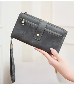 Dettaglio del portafoglio in pelle vintage grigio scuro con tasche e cinturino da polso