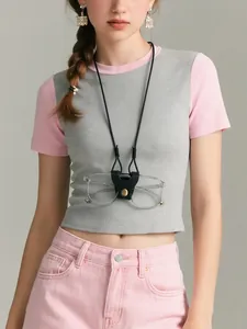 Detail of PU leather glasses holder with gold snap button worn as a fashion neck accessory