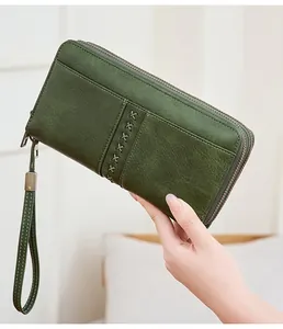 Dettaglio del portafoglio lungo verde scuro retrò con punto croce e doppia cerniera