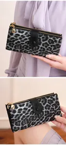 Detail of grey leopard print long wallet with double gold zippers and snap button closure