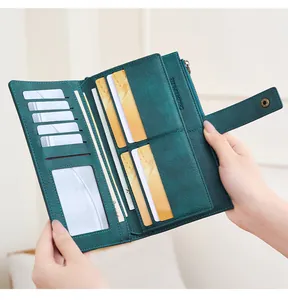 Dettaglio del portafoglio in pelle verde con scomparti per carte e layout interno