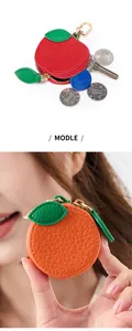 Détail de mini porte-monnaie en forme de fruits montrant la capacité intérieure d'objets