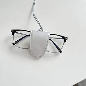 Detail view of silver metallic leather neck-strap glasses pouch with fine stitching