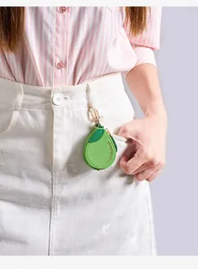 Porte-monnaie avocat en cuir avec crochet doré accroché à une boucle de jupe en jean