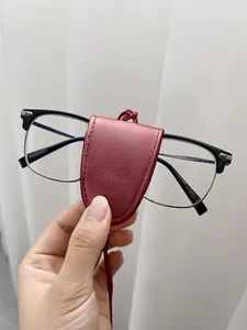 Detail of burgundy leather magnetic glasses holder with matching neck strap and stitching