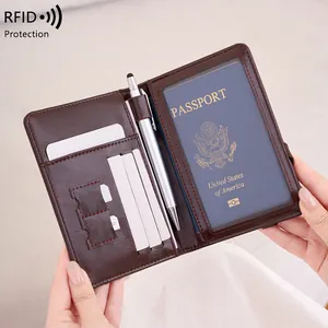 Dark brown RFID blocking passport wallet with card slots and pen holder held by hand