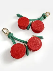 Detail of red cherry leather coin purse pendant with gold zipper and metal carabiner