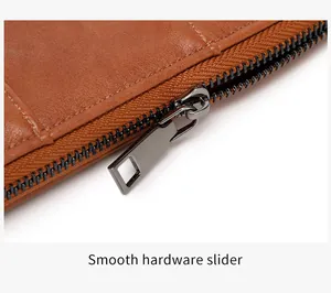 Detail of smooth metal zipper slider and premium brown leather texture with white stitching