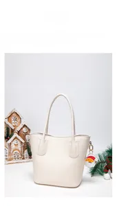 Detail of white pebbled leather handbag with Santa Claus charm and festive decor