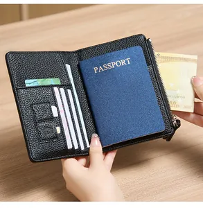 Detail view of black lychee leather passport wallet with card slots and a zipper pocket