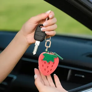 Mini portamonete a fragola rosa in ecopelle con fibbia dorata attaccato a una chiave