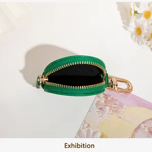 Vue macro du porte-monnaie en cuir vert avec fermeture éclair dorée et détail de fermoir