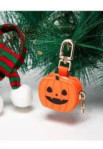Detalle del colgante de calabaza en cuero con cierre dorado sobre fondo decorativo festivo