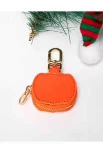 Detalle de llavero de calabaza de cuero naranja con mosquetón dorado para bolsos