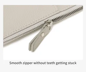 Detail of smooth silver zipper on lychee texture leather passport holder pouch