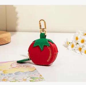 Détail du porte-monnaie en cuir en forme de tomate avec crochet doré et marquage à la main