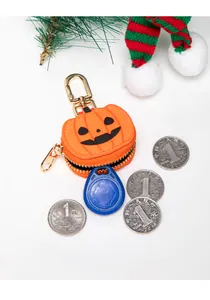 Detalle de mini monedero de calabaza con cara negra, cremallera dorada y gancho de metal