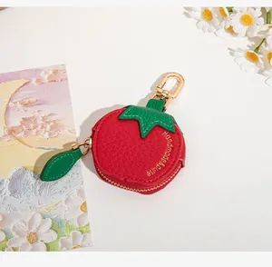 Détail du mini porte-monnaie en cuir rouge en forme de fruit avec fermeture éclair dorée