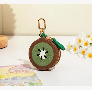 Détail d'un porte-monnaie en forme de kiwi avec texture cuir vert et clip doré
