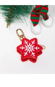 Detail of red star-shaped faux leather Christmas keychain coin pouch with white snowflake