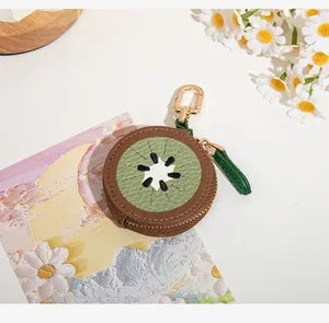 Détail du porte-monnaie kiwi créatif en cuir vert avec mousqueton doré et fermeture éclair