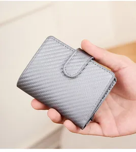 Porte-cartes RFID slim avec texture en fibre de carbone grise tenu par un homme