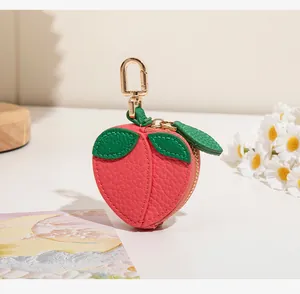 Macro d'un porte-monnaie pêche en cuir PU avec feuille verte et crochet doré chic