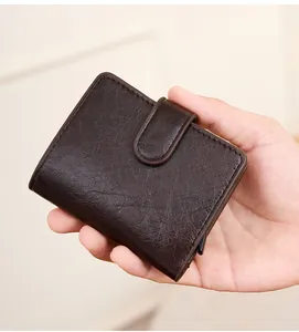 Portefeuille en cuir marron avec porte-cartes RFID automatique tenu en main
