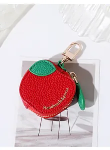 Détail du porte-monnaie pomme rouge avec fermeture éclair dorée et feuille verte