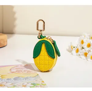 Détail du porte-monnaie citron en cuir litchi jaune avec mousqueton doré élégant