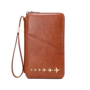 Brown leather RFID travel wallet with gold airplane accents and wrist strap