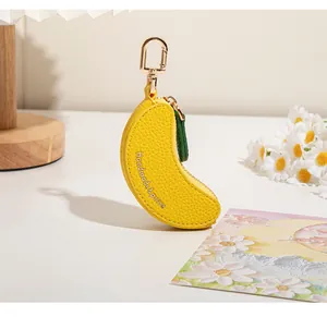 Détail du mini porte-monnaie jaune en cuir en forme de banane avec porte-clés doré