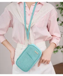 Close-up of light blue RFID travel pouch with metal TRAVEL plate and fabric texture